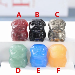 May include: Six small pug figurines made of different colored gemstones. The figurines are arranged in a row from left to right, labeled A through F. The figurines are made of red, black, gray, green, blue, and orange gemstones.