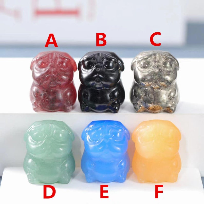 May include: Six small pug figurines made of different colored gemstones. The figurines are arranged in a row from left to right, labeled A through F. The figurines are made of red, black, gray, green, blue, and orange gemstones.