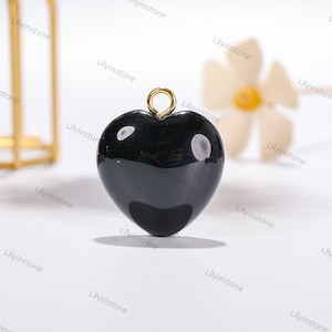 Peut inclure: Pendentif en forme de c&oelig;ur noir avec une b&eacute;li&egrave;re dor&eacute;e. Le pendentif est en onyx noir poli.