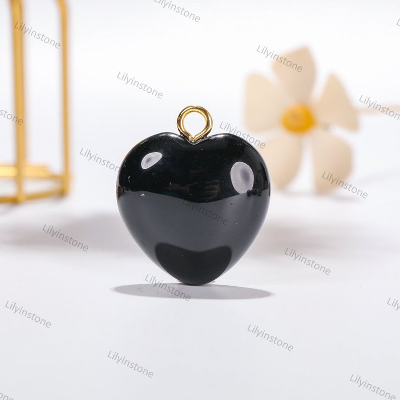 Peut inclure: Pendentif en forme de c&oelig;ur noir avec une b&eacute;li&egrave;re dor&eacute;e. Le pendentif est en onyx noir poli.