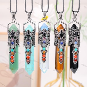May include: Five silver pendant necklaces with different coloured crystal stones. Each pendant features a silver filigree design and seven smaller stones in different colours. The stones are arranged in a vertical line, with a larger black stone at the top.