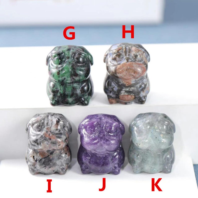 May include: Six small carved stone pug figurines. The pugs are in various colors, including green, purple, and gray. The pugs are all sitting with their paws tucked under them.