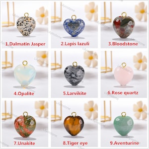 Peut inclure: Neuf pendentifs en forme de c&oelig;ur en diff&eacute;rentes pierres, dont le jaspe dalmatien, le lapis-lazuli, la bloodstone, l'opale, la larvikite, le quartz rose, l'unakite, l'&oelig;il de tigre et l'aventurine.