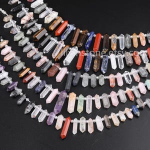 Puede incluir: Una hebra de cuentas de piedras preciosas, con varios colores y formas, incluyendo cuarzo transparente, amatista, cuarzo rosa, ojo de tigre y jaspe rojo. Las cuentas son facetadas y tienen una forma puntiaguda.