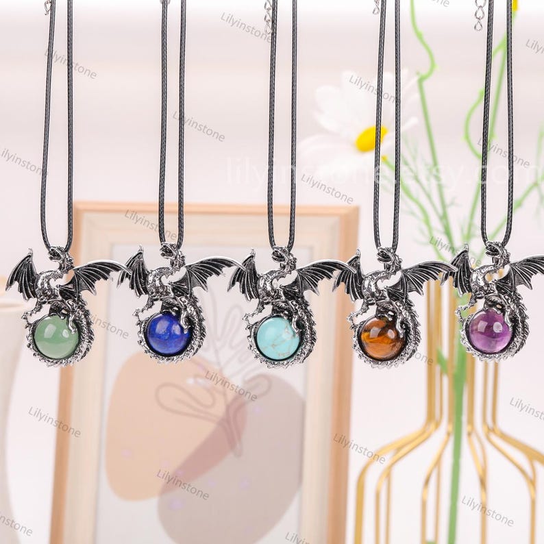 May include: Five silver dragon necklaces with different colored gemstone pendants. The gemstones are green, blue, turquoise, brown, and purple.