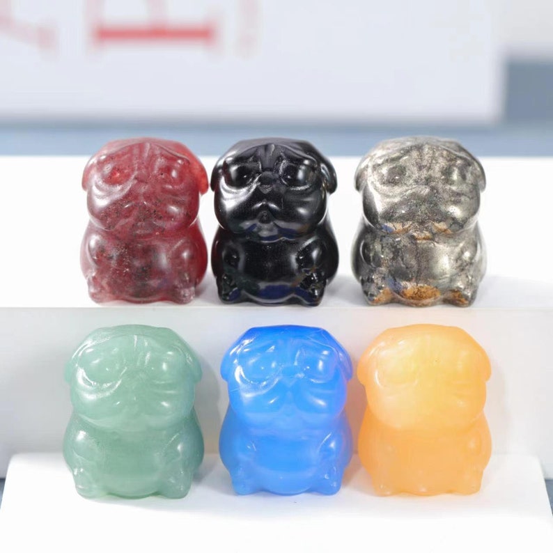May include: Six small, hand-carved pug figurines made of different colored gemstones. The pugs are all in a sitting position with their paws tucked under them. The colors of the gemstones are red, black, silver, green, blue, and orange.