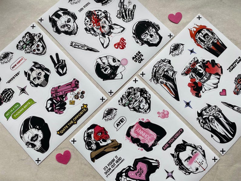 Puede incluir: Cuatro hojas de pegatinas blancas con ilustraciones gr&aacute;ficas en negro, blanco y rojo de calaveras, m&aacute;scaras t&aacute;cticas, equipo militar y gestos con las manos. El texto incluye frases como STAY FROSTY, MASK STAYS ON, GHOSTED, HOW COPY y AYE.