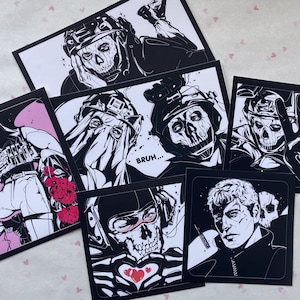 May include: A white ceramic mug with a black handle and the text "But First, Coffee" in a bold, black font. The mug is set against a blurred background, suggesting a cozy setting.