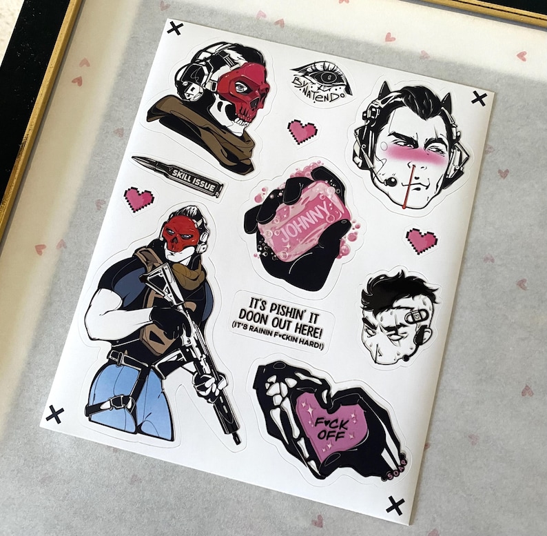 Puede incluir: Una hoja de pegatinas con varias ilustraciones, incluyendo un personaje con m&aacute;scara de calavera roja, una bala con la etiqueta SKILL ISSUE, una mano sosteniendo una pastilla de jab&oacute;n con la etiqueta JOHNNY, un personaje con auriculares y el texto IT'S PISHIN' IT DOON OUT HERE!