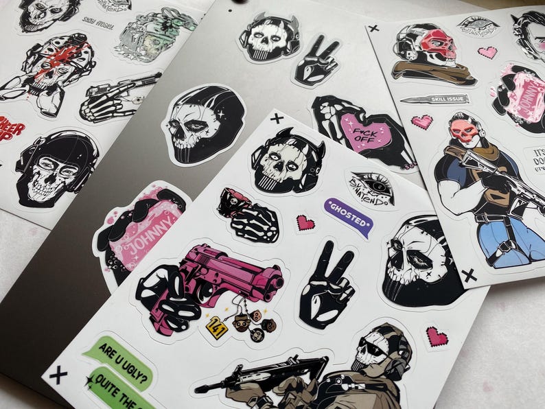 Puede incluir: Una colecci&oacute;n de pegatinas de vinilo con diversas ilustraciones gr&aacute;ficas que incluyen m&aacute;scaras de calavera, equipo t&aacute;ctico, armas de fuego rosas, manos de esqueleto y elementos de texto como "GHOSTED", "JOHNNY" y "ARE U UGLY?" en hojas adhesivas.