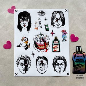 May include: A sheet of stickers featuring various black and white illustrations, including faces, a cake, and a bottle of mouthwash. A bonus sticker of the mouthwash bottle is also included. Pink heart-shaped decorations are placed around the sheet.