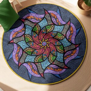 May include: A round rug with a colorful mandala design. The mandala features a swirling pattern of blue, green, red, yellow, and purple. The rug is surrounded by a beige border.