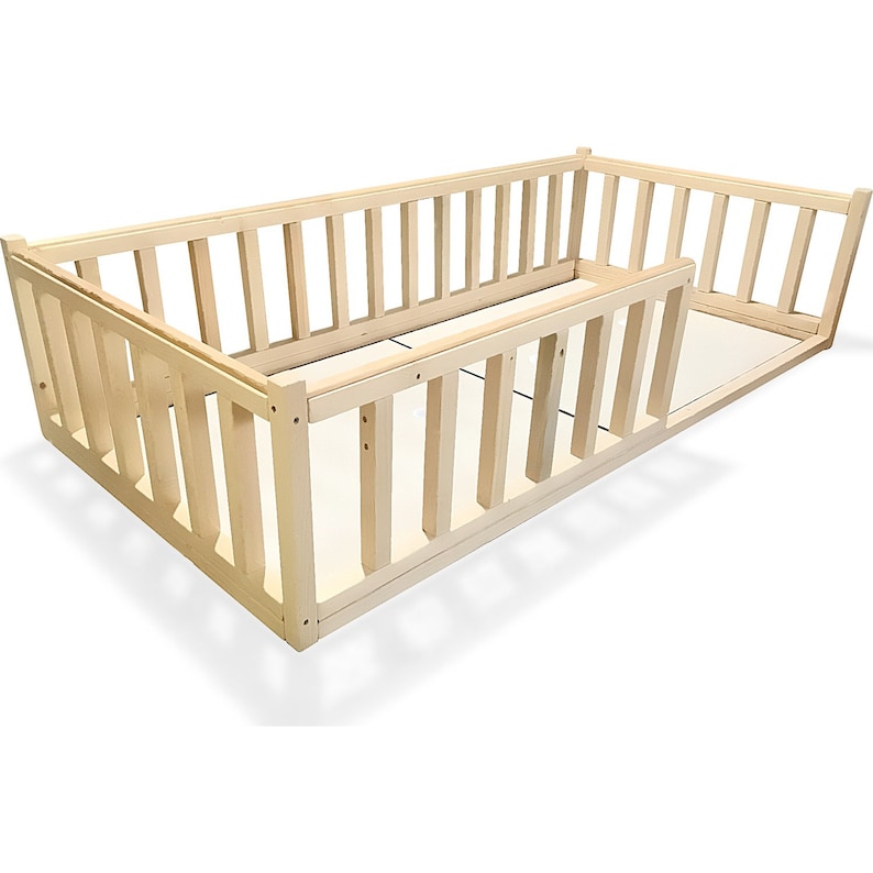 May include: A natural wood baby playpen with a rectangular shape and a removable side panel. The playpen has a slatted design and is made of unfinished wood.