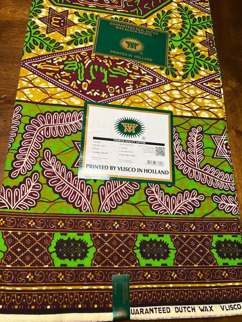 Peut inclure: Un tissu vert, marron et jaune avec un motif g&eacute;om&eacute;trique. Le tissu est &eacute;tiquet&eacute; "Guaranteed Real Dutch Wax Block Prints" et "Printed by Vlisco in Holland".
