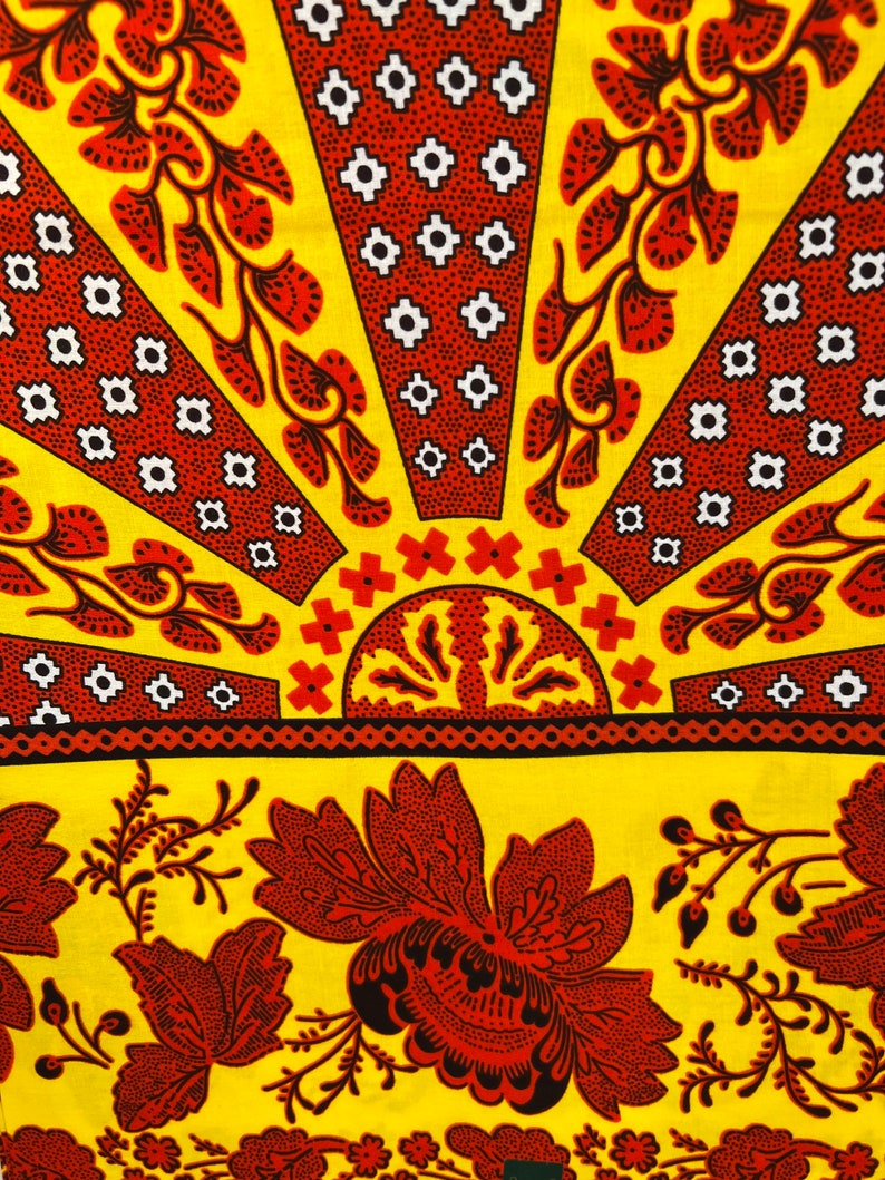 Puede incluir: Una tela amarilla con un patr&oacute;n floral rojo y negro. La tela tiene un patr&oacute;n repetitivo de flores y hojas. La tela es perfecta para acolchar, coser y hacer manualidades.