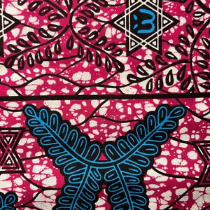 Op de afbeelding: Close-up van een levendige stof met een herhalend patroon. Het ontwerp heeft een magenta achtergrond met witte spikkels en zwarte en blauwe gestileerde blad- en geometrische vormen. De stof heeft een gedurfde, opvallende esthetiek.