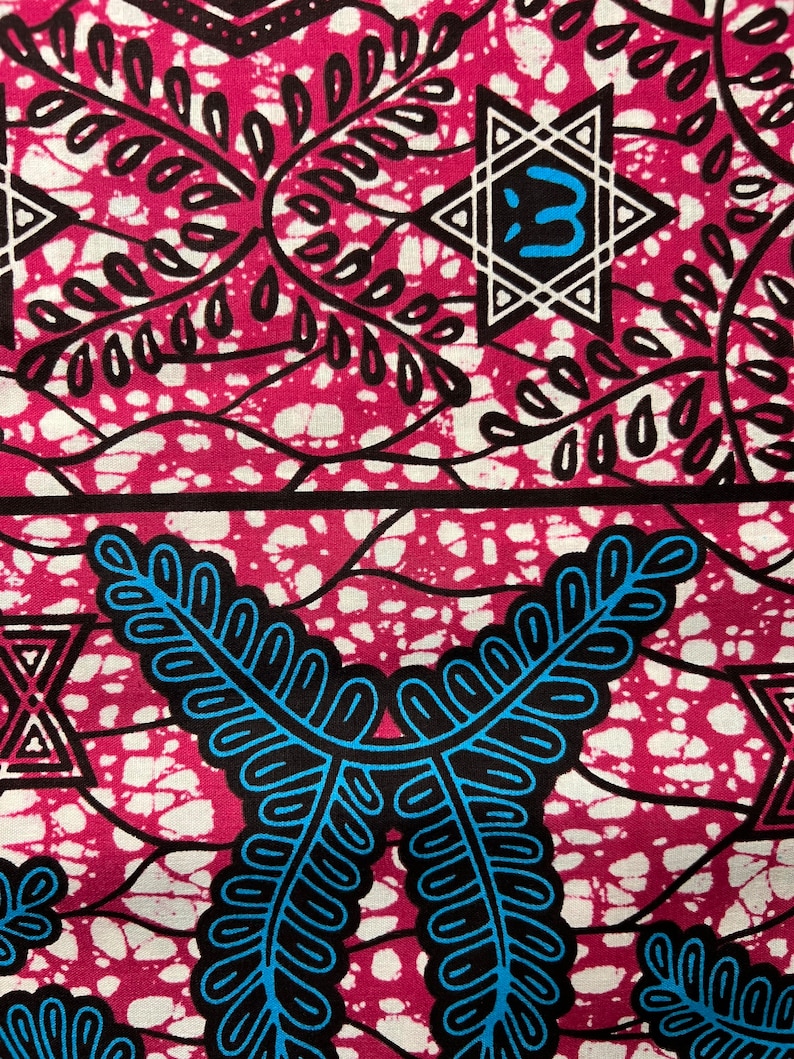 Op de afbeelding: Close-up van een levendige stof met een herhalend patroon. Het ontwerp heeft een magenta achtergrond met witte spikkels en zwarte en blauwe gestileerde blad- en geometrische vormen. De stof heeft een gedurfde, opvallende esthetiek.