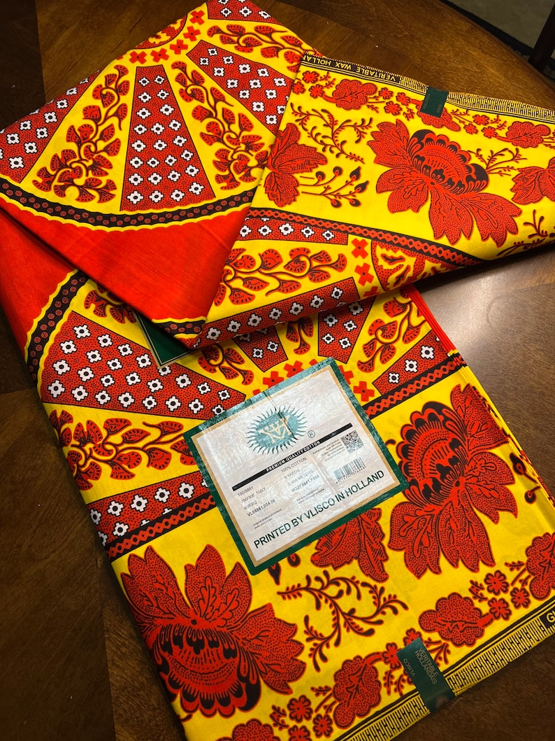 Puede incluir: Una tela amarilla y roja con un patr&oacute;n floral. La tela est&aacute; impresa con el texto "PRINTED BY VLISCO IN HOLLAND" y "VERITABLE WAX HOLLANDAIS".
