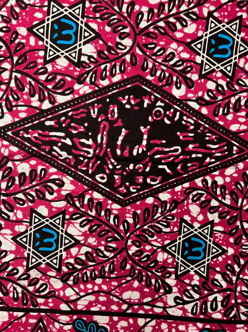 Op de afbeelding: Een levendig textiel met een herhalend patroon van witte stervormen met een blauwe letter 3, zwarte ruitvormen en bladmotieven op een magenta achtergrond. De stof heeft een getextureerd uiterlijk.