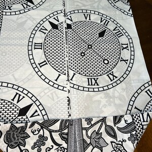 May include: Black and white fabric with a repeating pattern of Roman numeral clocks. The fabric has a floral design with vines and grapes.