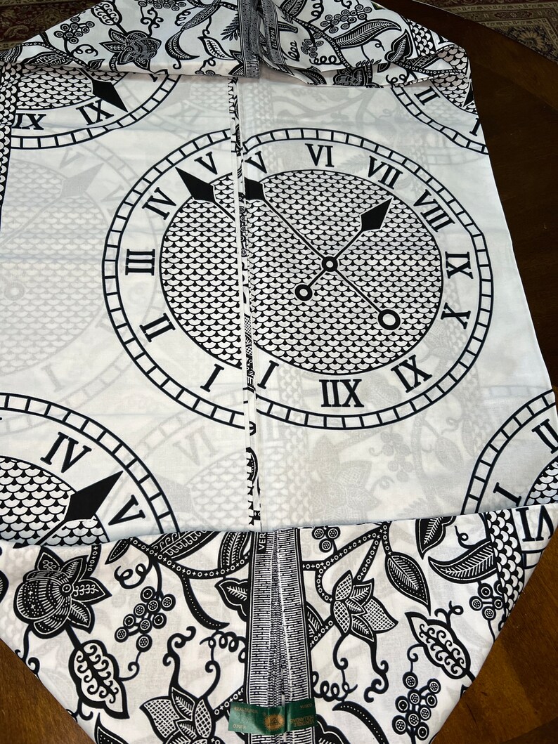 May include: Black and white fabric with a repeating pattern of Roman numeral clocks. The fabric has a floral design with vines and grapes.