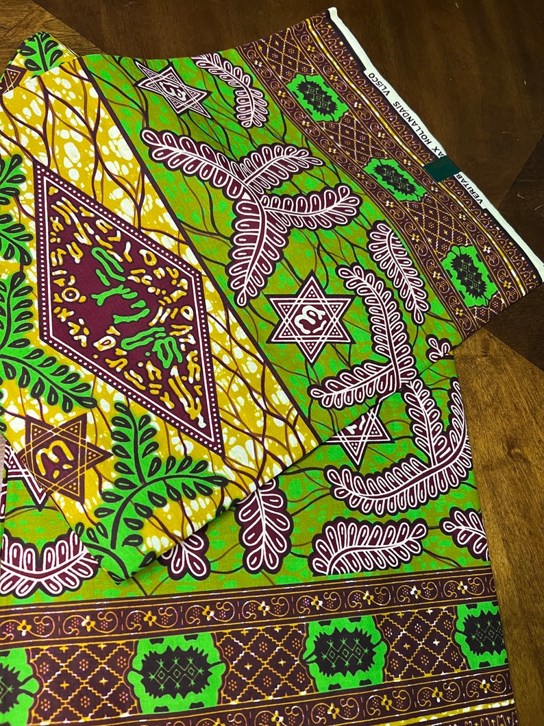 Peut inclure: Tissu vert et marron avec un motif r&eacute;p&eacute;titif de feuilles, d'&eacute;toiles et de diamants. Le tissu porte une &eacute;tiquette indiquant "VERITAS" et "MAX HOLLANDS - VLSO".