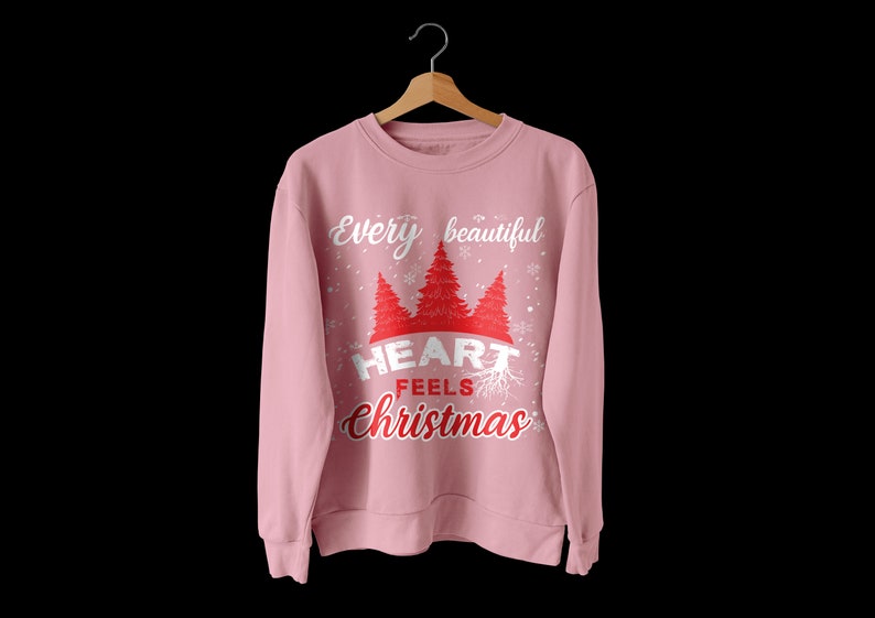 May include: Pink sweatshirt with a white graphic that says "Every beautiful heart feels Christmas" with a red heart and stylized trees.