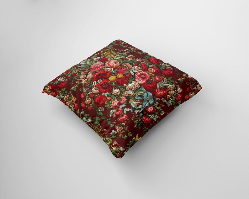 May include: A red throw pillow with a floral pattern featuring a variety of red, pink, and white flowers. The pillow is made of a soft, comfortable fabric and is perfect for adding a touch of elegance to any room.