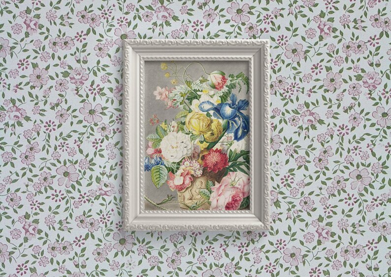 Op de afbeelding: Een ingelijste bloemenprint met een levendig boeket rozen, irissen en andere bloemen in roze, geel, blauw en wit. Het kunstwerk is geplaatst tegen een grijze achtergrond in een witte, sierlijke lijst, tentoongesteld op bloemenbehang.