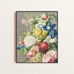 Op de afbeelding: Een ingelijste bloemenprint met een levendig boeket bloemen. De compositie bevat gele rozen, blauwe irissen en roze rozen, tegen een grijze achtergrond. Het kunstwerk is in vintage stijl, met een zwarte lijst.