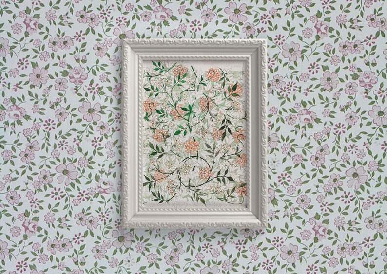May include: A white framed print with a floral design in shades of green, orange, and white. The print is set against a background of a floral wallpaper with pink and green flowers.