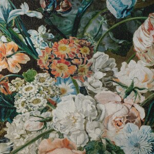 Op de afbeelding: Een close-up van een stoffen print met bloemen, met verschillende bloemen in tinten roze, wit, blauw en oranje. De stof heeft een textuur die lijkt op canvas.
