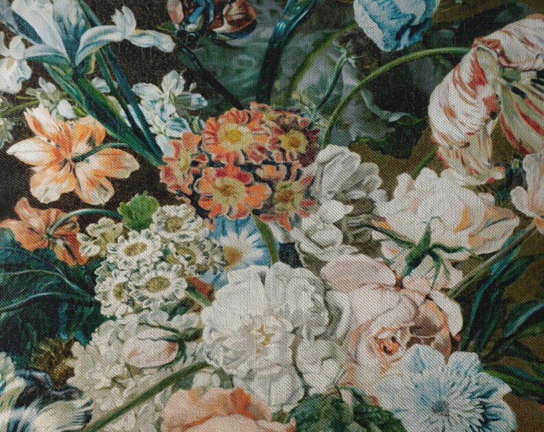 Op de afbeelding: Een close-up van een stoffen print met bloemen, met verschillende bloemen in tinten roze, wit, blauw en oranje. De stof heeft een textuur die lijkt op canvas.