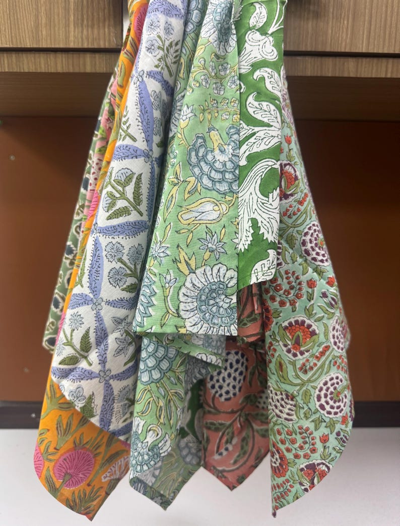 Puede incluir: Una colecci&oacute;n de servilletas de tela estampadas y coloridas. Las servilletas presentan dise&ntilde;os florales y bot&aacute;nicos en tonos verdes, azules, naranjas y rosas. La tela parece ser de algod&oacute;n o un material similar, con un aspecto ligeramente texturizado.