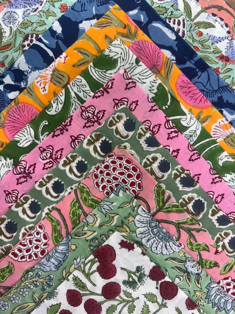 Puede incluir: Una colecci&oacute;n de cuadrados de tela coloridos y estampados. Las telas presentan dise&ntilde;os florales y bot&aacute;nicos en tonos de rosa, verde, azul y naranja. Los patrones incluyen flores, hojas y bayas, creando una exhibici&oacute;n vibrante y art&iacute;stica.