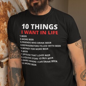 Könnte beinhalten: Ein schwarzes T-Shirt mit weißem Text, der "10 DINGE, DIE ICH IM LEBEN WILL" lautet und zehn Dinge auflistet, die mit Bier zu tun haben.
