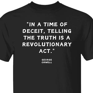 May include: Black t-shirt with white text that reads "IN A TIME OF DECEIT, TELLING THE TRUTH IS A REVOLUTIONARY ACT."  The text is attributed to George Orwell.