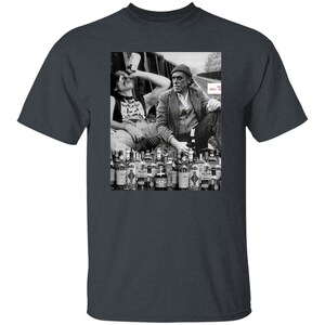 May include: Black and white photo of two men sitting on a railroad track with a large number of liquor bottles in front of them. The text "This is our life" is visible in the image.