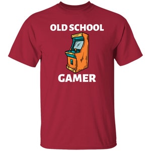 K&ouml;nnte beinhalten: Rotes T-Shirt mit wei&szlig;em Text "Old School Gamer" und einem Cartoon-Bild eines Arcade-Spiels.