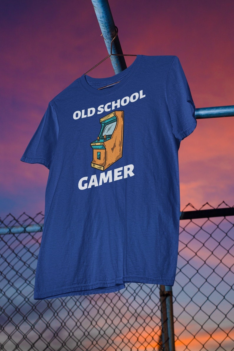 K&ouml;nnte beinhalten: Ein k&ouml;nigsblaues T-Shirt mit einer wei&szlig;en Grafik eines Old-School-Arcade-Spiels und dem Text "OLD SCHOOL GAMER".