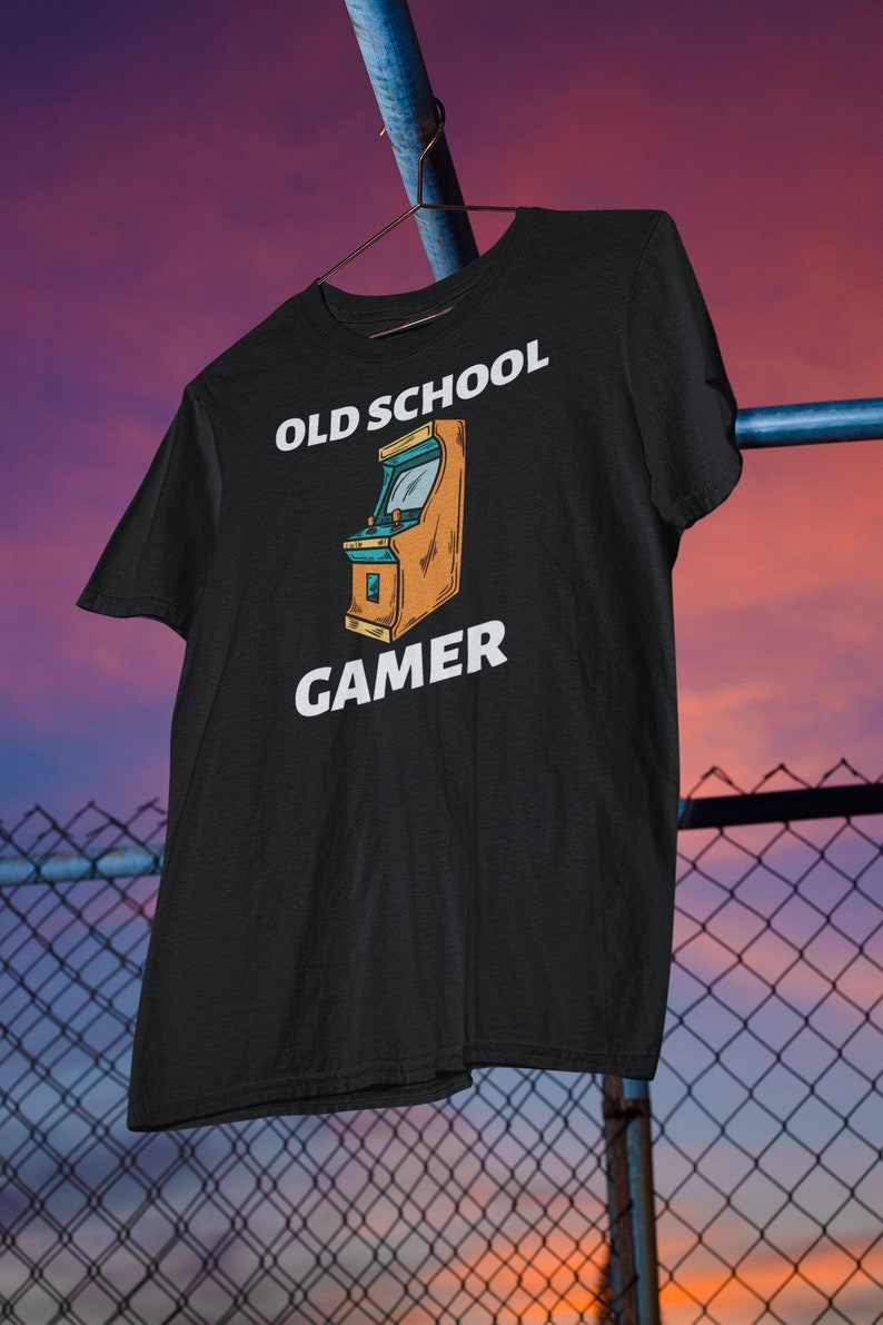 K&ouml;nnte beinhalten: Schwarzes T-Shirt mit einer wei&szlig;en Grafik eines Old-School-Arcade-Spiels und dem Text "OLD SCHOOL GAMER".