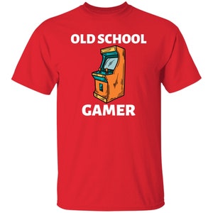 K&ouml;nnte beinhalten: Rotes T-Shirt mit einer wei&szlig;en Grafik eines Old-School-Arcade-Spiels und dem Text "OLD SCHOOL GAMER".