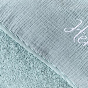 Puede incluir: Una manta de muselina para beb&eacute; de color azul claro con un suave respaldo de felpa de rizo. La manta est&aacute; personalizada con el nombre "Henry" bordado en hilo blanco.
