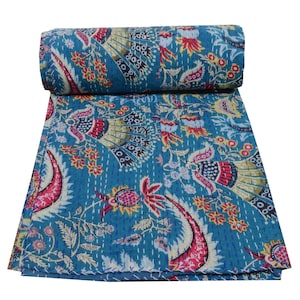 May include: A blue kantha quilt with a floral and paisley pattern. The quilt is hand-stitched and features a variety of colours, including pink, yellow, and green.