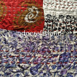 Könnte beinhalten: Eine Patchwork-Decke aus bunten Stoffresten. Die Decke ist mit rotem Garn zusammengenäht und zeigt verschiedene Blumenmuster. Die Decke ist ein einzigartiges und handgemachtes Kunstwerk.