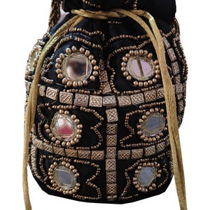 May include: A black drawstring bag with gold and silver embellishments. The bag is decorated with small mirrors and beads.
