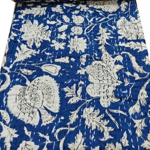 Peut inclure: Une courtepointe kantha bleue et blanche avec un motif floral. La courtepointe est en coton et est cousue à la main.