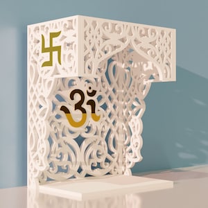 Puede incluir: Estante decorativo de madera blanca con intrincados recortes y un símbolo Om dorado y un símbolo Swastika dorado.