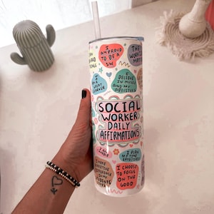 May include: A white tumbler with a straw, featuring the text "Social Worker Daily Affirmations" in a colorful design. The tumbler is covered in positive affirmations in various colors and shapes.