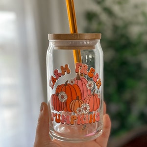 May include: A glass jar with a bamboo lid and a straw. The jar has a graphic of pumpkins with the text "Farm Fresh Pumpkins" in a retro font.